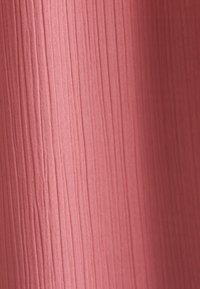 Tessuto in un morbido colore rosa con una texture a righe verticali, dotato di una leggera lucentezza e una finitura liscia.