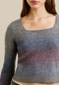 Grauer Strickpullover mit langen Ärmeln, quadratischem Ausschnitt und einem Farbverlauf, der von Grau zu Hauch von Rosa und Blau übergeht.