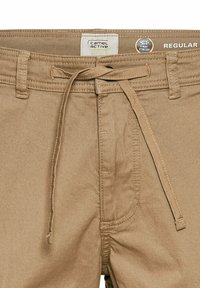 Beige katoenen broek met een trekkenkoord in de taille, 2-weg stretchstof en zichtbare stikdetails. Heeft zijzakken en een etiket.