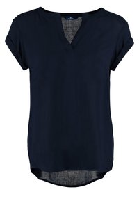Blouse bleu marine à manches courtes avec col en V et poignets retroussés, avec un ourlet légèrement arrondi et un tissu léger.
