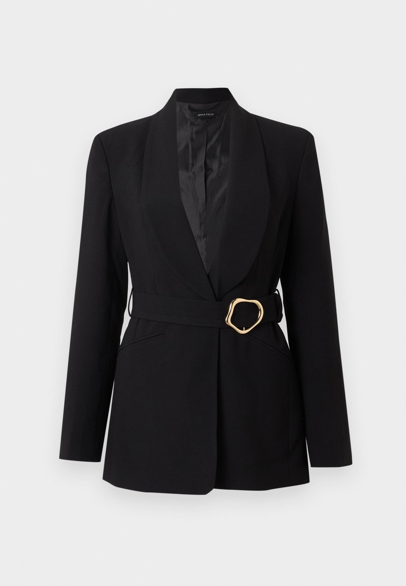 Blazer noir sur mesure avec col châle et ceinture assortie présentant une boucle dorée irrégulière, affiché sur un fond clair uni.