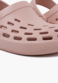 Zoccoli leggeri rosa con fori di ventilazione, punta arrotondata, bordi testurizzati e finitura liscia. Realizzati in plastica durevole e flessibile.