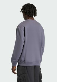 Szara bluza z crew neck, ściągaczami na rękawach i u dołu. Wykonana z miękkiego materiału, z luźnym krojem i bezszwowym designem ramion.