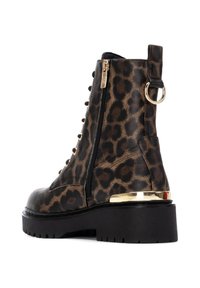 Botas de tobillo de piel de leopardo con acabado de cuero sintético texturizado, suela negra de goma con dentado, cremallera lateral y acento dorado en el tacón.