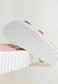 Roze suède instappers met een wit rubberen zool met hexagonaal patroon. Heeft een natuurlijke kurken voetbed en een ronde vorm.
