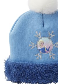 Lichtblauwe gebreide wintermuts met een donkerblauwe donzige rand, witte pompon en sneeuwvlokmotief met een blond meisje in een blauwe jurk.