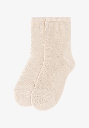 Par de calcetines beige hasta el tobillo, tejidos con un sutil patrón diagonal y puños acanalados.