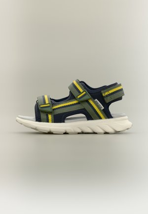 Sandale bleu marine avec des rayures vertes et jaunes, fabriquée en matériau respirant. Dispose de deux sangles réglables et d'une semelle en caoutchouc blanche.