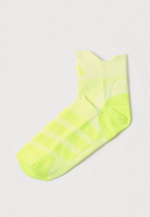 Șosetă pentru gleznă de culoare galben neon, cu un model texturat, prezentând dungi diagonale și un manșon striat pentru o potrivire și confort îmbunătățite.