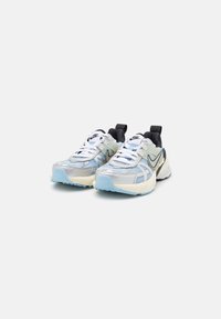 Nike sneakers with a mesh and synthetic upper in white, light blue, and black. Features a thick, textured sole and prominent lacing system.