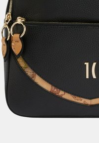 Czarna skórzana torba z teksturowaną powierzchnią, złotymi akcentami i zakrzywionym motywem z mapa. Złote litery wyświetlają "10".