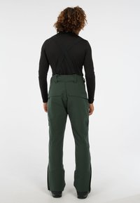 Groene sneeuwbroek met verstelbare banden, ritszakken en een taps toelopend ontwerp. Glad, duurzaam materiaal met een matte afwerking.