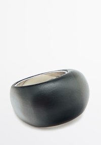 Zwarte leren manchetarmband met een gladde, afgeronde vorm en een gepolijst zilveren interieur. Minimalistisch ontwerp, zonder extra accenten of patronen.