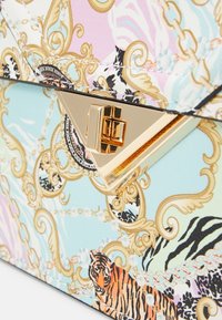 Bolso multicolor con un cierre en tono dorado, intrincada cadena y diseños de estampado animal, con una superficie suave y texturada.
