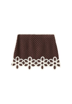 Mini-jupe marron en crochet avec un bord en dentelle blanche en forme de fleur le long de l’ourlet, présentant un motif carré texturé sur toute la surface du tissu.