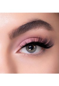 Primo piano di un occhio con lunghe e folte ciglia nere, ombretto rosa chiaro e un'iride grigia chiara con una pupilla scura. La texture della pelle appare liscia.