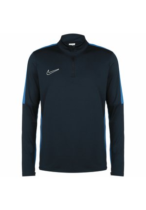 Marineblauw sportshirt met lange mouwen en een halve ritssluiting. Bevat blauwe accenten op de mouwen en een wit Nike-logo op de borst. Een gladde stof.