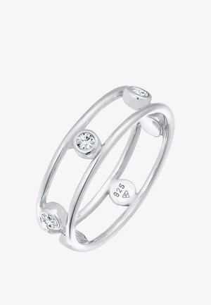 Srebrny pierścionek wykonany z użyciem srebra próby 925, z podwójnym wzorem obrączki i trzema okrągłymi, przezroczystymi kamieniami osadzonymi w okrągłych akcentach.