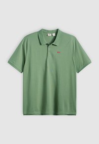 Zelena polo majica od pamuka, s kragnom, kratkim rukavima i malim crvenim logom na prsima. Glatka tekstura, standardni kroj.
