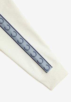 Manica di felpa bianca con polsino a coste testurizzato e un design blu navy con motivi di alloro su una striscia azzurro chiaro.