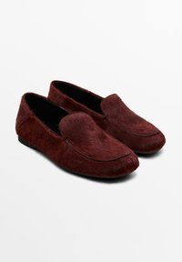 Scarpe slip-on bordeaux con materiale morbido e peloso dalla texture e cuciture nere a contrasto. Punta arrotondata e suola bassa e piatta.