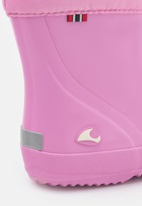 Rosa gummistövlar med en slät, blank yta. Har en vit logotyp, grå detaljer och en strukturerad sula för bra grepp. Överdelen har en tygkant.