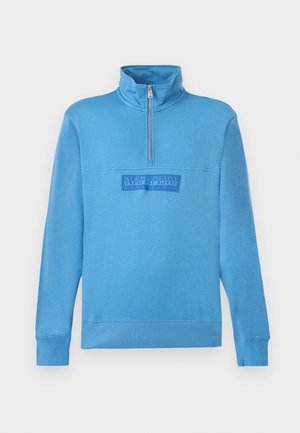 Jasnoniebieski sweter z długim rękawem z ćwiartkowym zamkiem błyskawicznym i wysokim kołnierzem, z centralnie umieszczoną naszywką z logo "Napapijri geographic" na piersi.