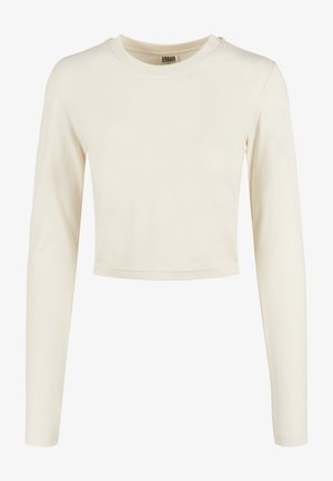 Kremowy crop top z długim rękawem wykonany z miękkiej bawełny. Posiada okrągły dekolt i dopasowany krój, z czystymi krawędziami i minimalistycznym designem.