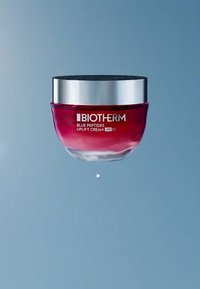 Biotherm Blue Peptides Uplift Cream i en rund glasskrukke; gradient rød til klar, sølv skrulokk, SPF 50-merke på fronten.
