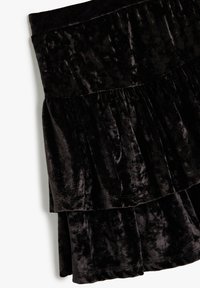 Schwarze Samtrock mit geschichtetem Design. Verfügt über eine ausgestellte Silhouette, eine weiche Textur und Raffungen an der Taille für zusätzlichen Detailreichtum.