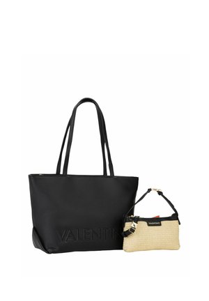 Bolso tote de cuero negro texturizado con asas largas y una pequeña pulsera beige tejida con ribete negro y detalles de hebilla dorada.