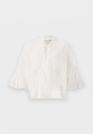 Λευκό φαρδύ λινό πουκάμισο με φαρδιά 3/4 μανίκια με βολάν, μπροστινή τσέπη στο στήθος και λεπτομέρεια στη λαιμόκοψη με δέσιμο από τη Munthe.