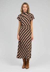 La robe maxi comporte une base noire avec des rayures verticales marron et blanches. Manches courtes, col haut et ceinture en tissu assortie.