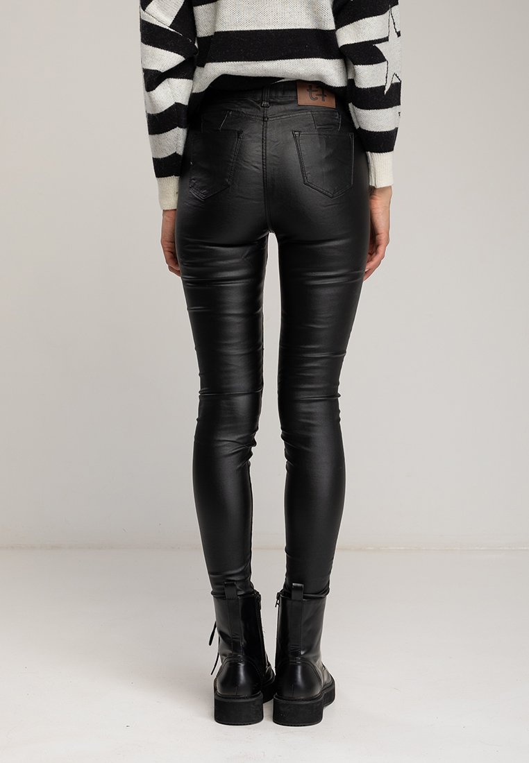 Zwarte nep leren broek met een slim fit, soepele textuur en minimale detailing. Draag met zwarte veterschoenen tot de enkel.