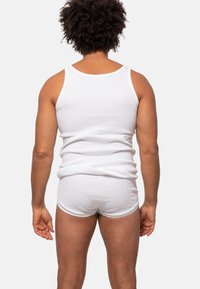 Witte geribde tanktop en bijpassende shorts, beide van katoen. De tanktop heeft een ronde halslijn en brede armsgaten, met een aansluitende pasvorm.