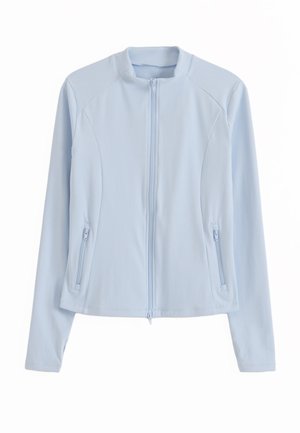 Light blue long-sleeve zip-up jacket with stand collar and zippered side pockets, designed with panel seams for a fitted look.