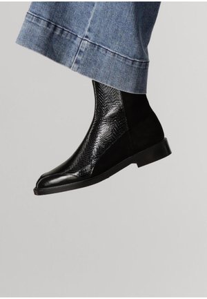 Black ankle boot featuring a textured snake-embossed leather panel and smooth leather accents. Chunky sole, sleek design, subtle shine.