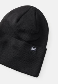 Gorro de punto negro con un puño doblado y una etiqueta redonda del logo de Buff. Presenta una textura suave y una forma clásica y aerodinámica.