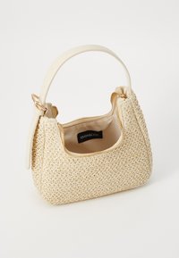 Beżowa pleciona torebka o ustrukturowanym kształcie, wyposażona w pojedynczy górny uchwyt i zapięcie na zamek. Wnętrze wyściełane, z widoczną metką marki.