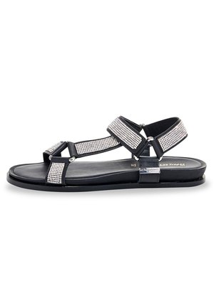 Sandalia negra con acentos de strass, con correas ajustables, suela plana y un diseño minimalista. Textura suave y materiales duraderos.