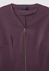 Lila Oberteil mit V-Ausschnitt, Reißverschluss mit goldfarbenen Akzenten und zwei Fronttaschen. Hergestellt aus glattem Stoff mit einem strukturierten Design.