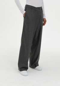 Grijze broek met streepjes in een op maat gemaakte pasvorm, met een platte voorkant, riemlussen en zijzakken, gecombineerd met witte sneakers.