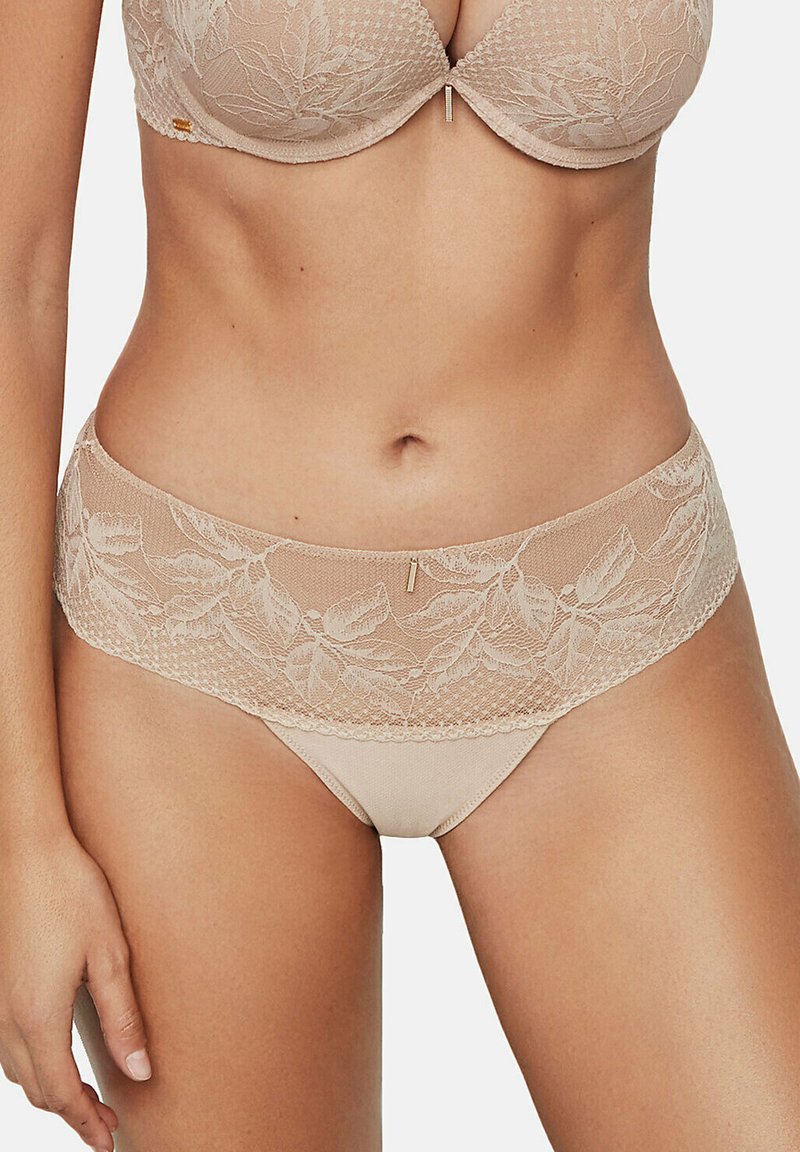 Beige kanten bh en bijpassende slip. Bevat bloemige kantaccenten, gestructureerd mesh en een gouden hardware detail op de tailleband van de slip.