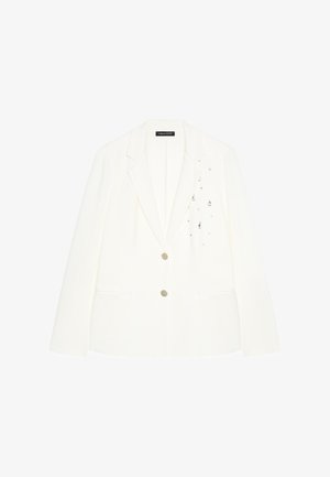Blazer blanc avec deux boutons devant, revers structurés, deux poches et petites décorations argentées sur la partie droite de la poitrine.