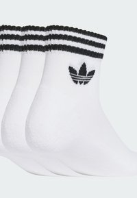 Hvite sokker med svarte striper ved kanten, med en svart logo på siden. Mykt stoff, ankellengde design, og pakke med fire.