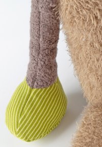 Jambe de jouet en peluche douce en tissu texturé brun avec un pied rayé vert, forme arrondie et détails de couture visibles.
