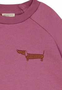 Felpa viola con un design di un bassotto ricamato marrone. Presenta un collo rotondo con chiusura a bottone a pressione e un tessuto testurizzato.