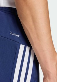 Σκούρα μπλε αθλητικό σορτς με λευκές ρίγες, με λογότυπο CLIMACOOL. Λείο, αναπνεύσιμο ύφασμα με εφαρμοστή σχεδίαση.