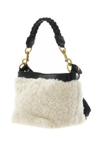 Sac en cuir noir avec une section inférieure en fausse fourrure crème texturée. Dispose d'une poignée tressée, d'une quincaillerie dorée et d'une forme structurée.