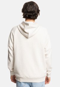 Jasno beżowa bluza z kapturem na sznurki, z prążkowanymi mankietami i dołem, z teksturowanej tkaniny oraz rękawami raglanowymi.